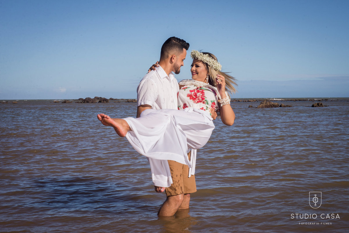 carregando noiva na praia