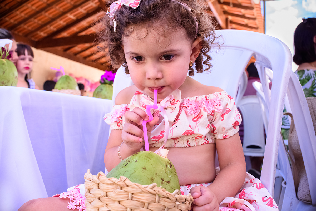 Alice tomando água de coco no canudinho. Coco da praia Vitória 