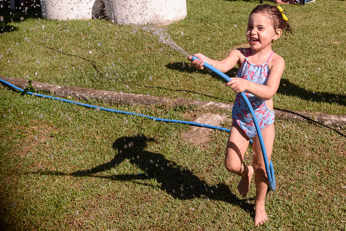 Alice dando banho de mangueira nos amigosAlice em Cariacica, Vitória, Espirito Santo ES, Sítio da Lala, fotografia por Thaty Maldaner Fotografia