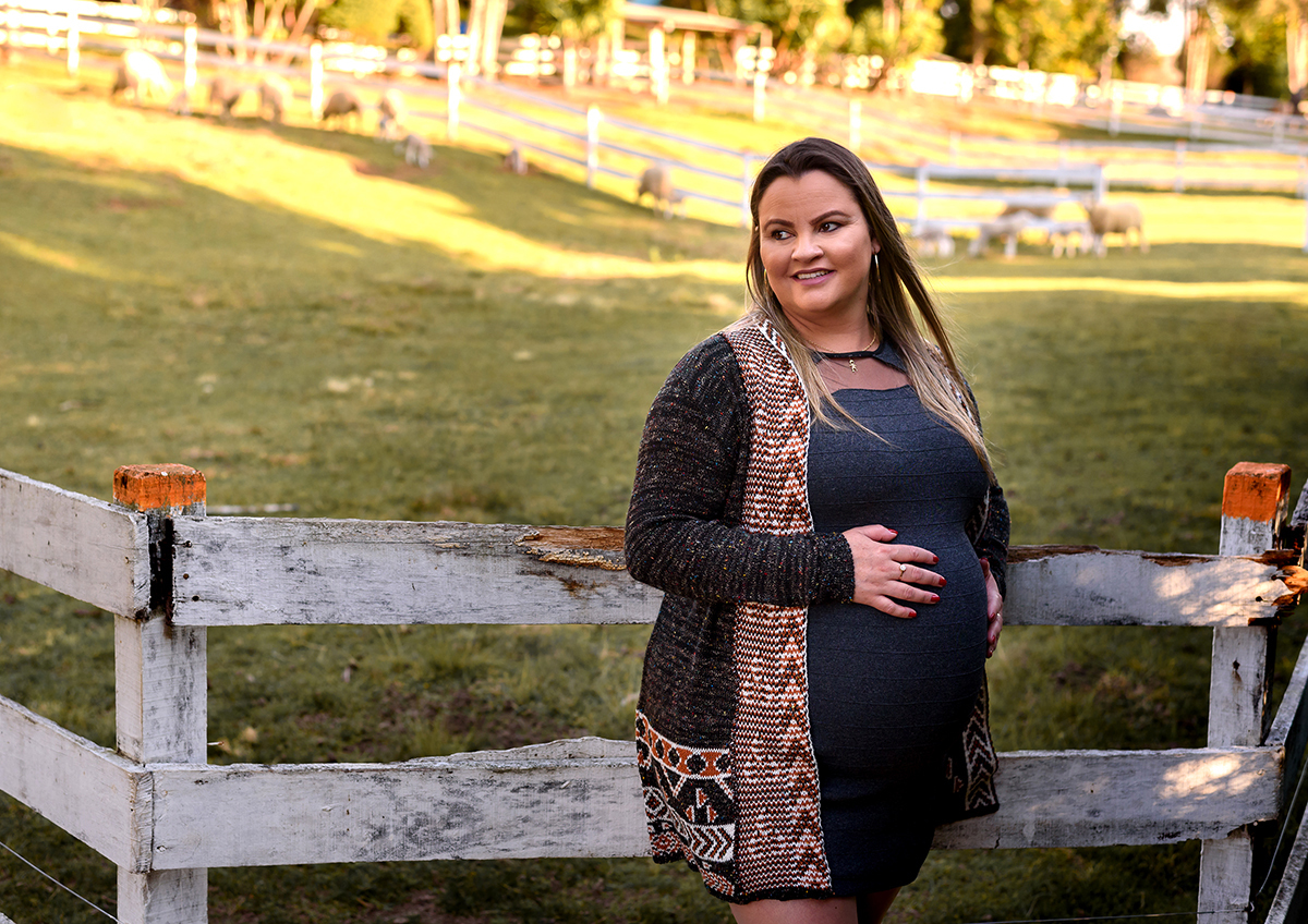 gestante na cerca das ovelhas do parque das tuias para ensaio de inverno book externo