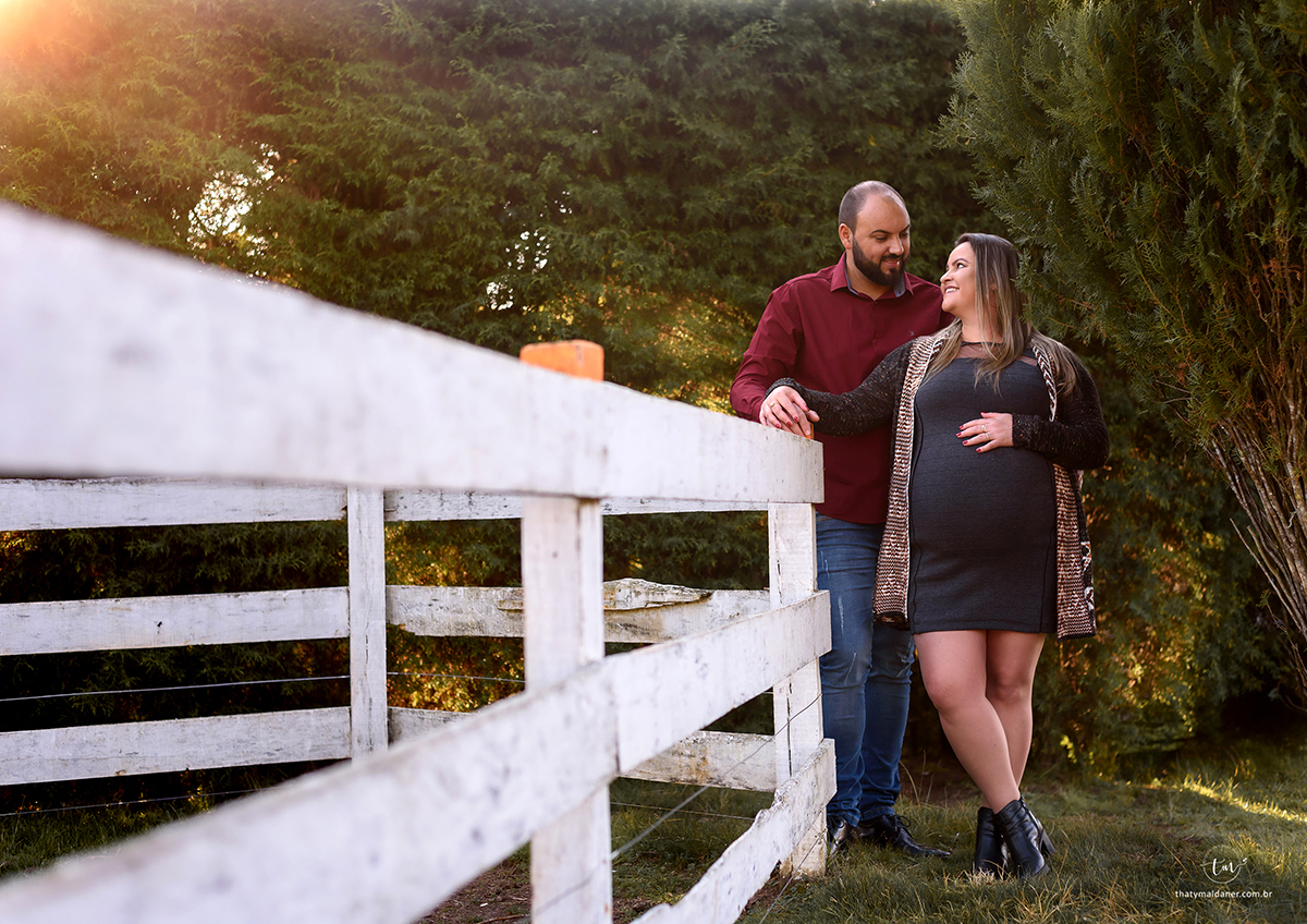 casal de gravidos na cerca das ovelhas do parque das tuias para ensaio de inverno book externo