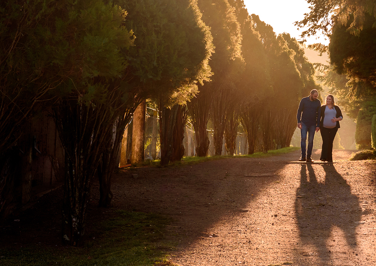 foto de book de gestante e casal no contra luz de fim de tarde, sol forte iluminando a gravides