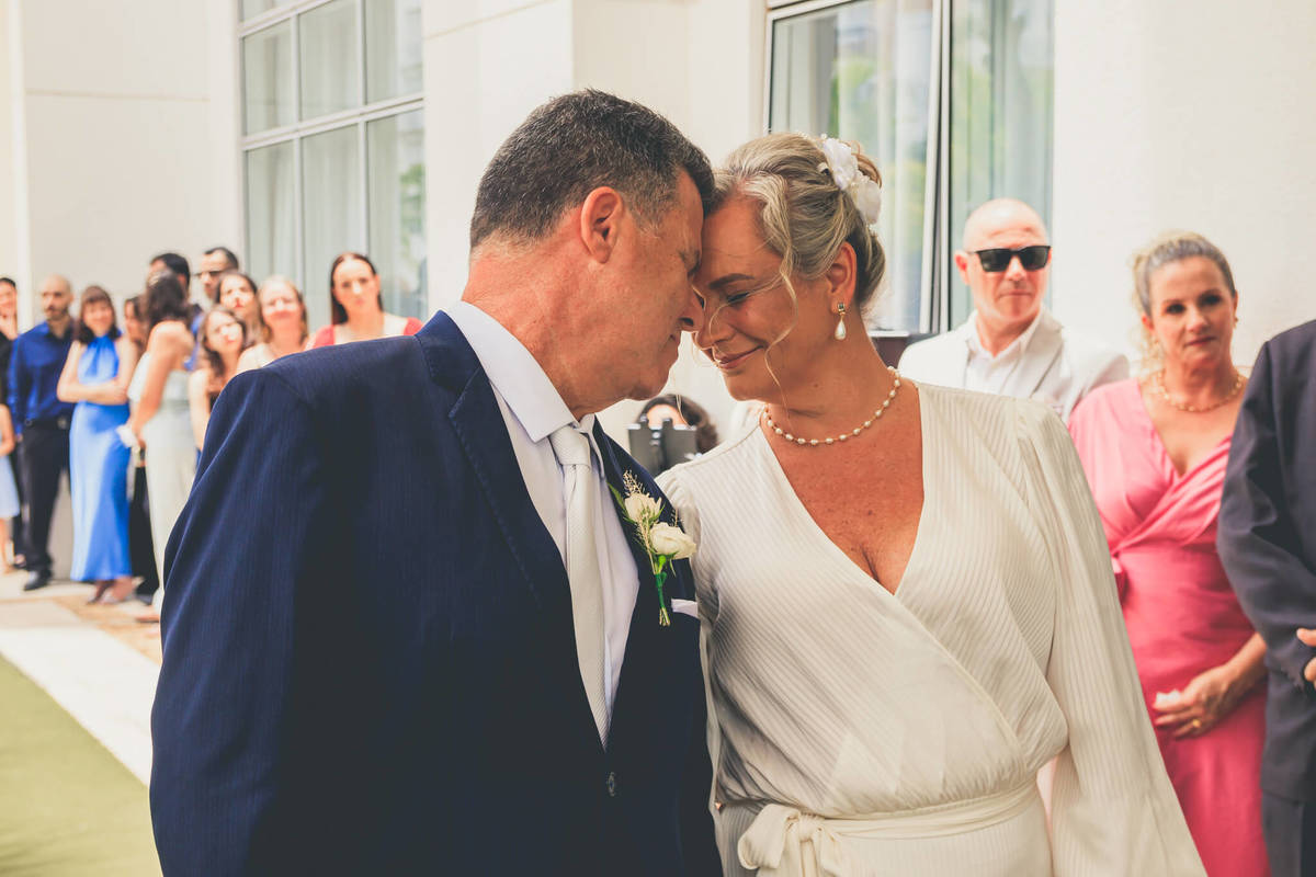 Ana e Paulo trocando olhares apaixonados durante a cerimônia de casamento em Florianópolis