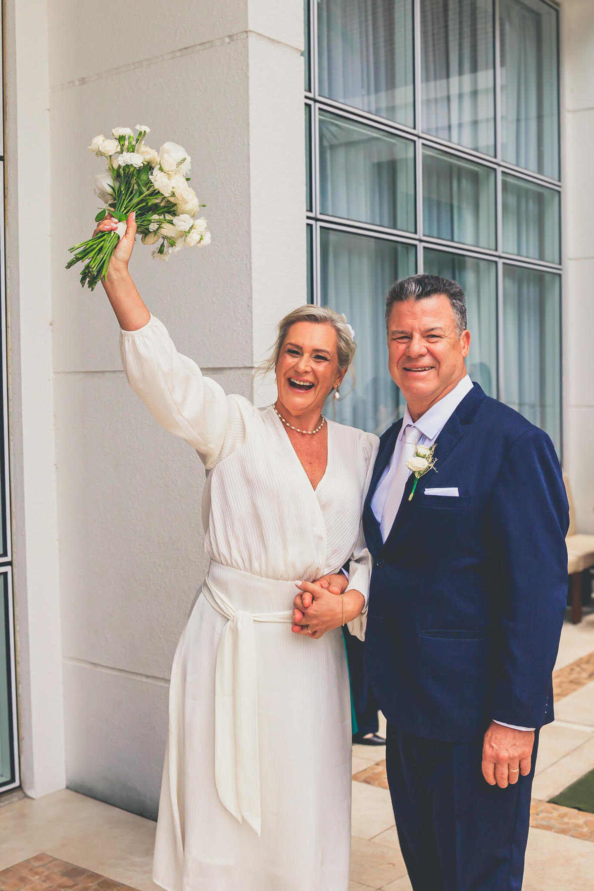 Os noivos posando juntos após a cerimônia, com a paisagem natural de Florianópolis ao fundo