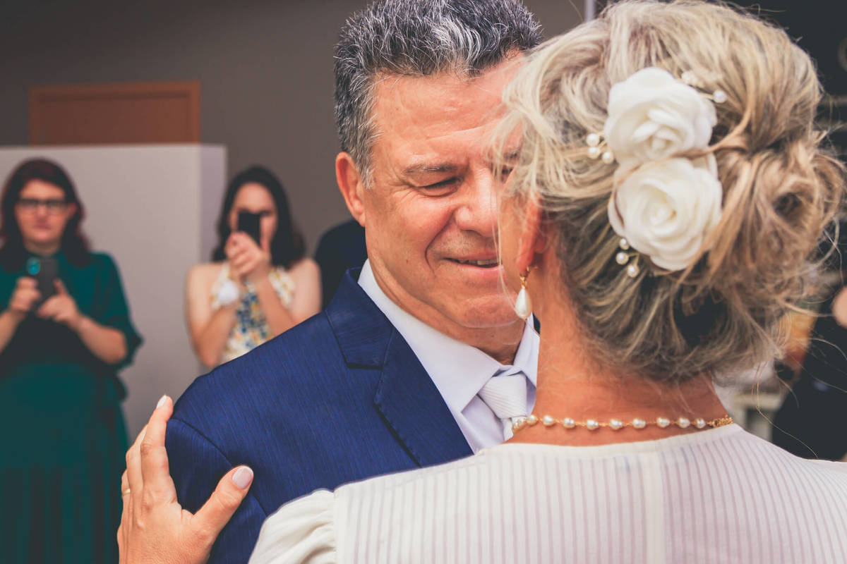 Ana e Paulo trocando olhares apaixonados durante a cerimônia de casamento em Florianópolis