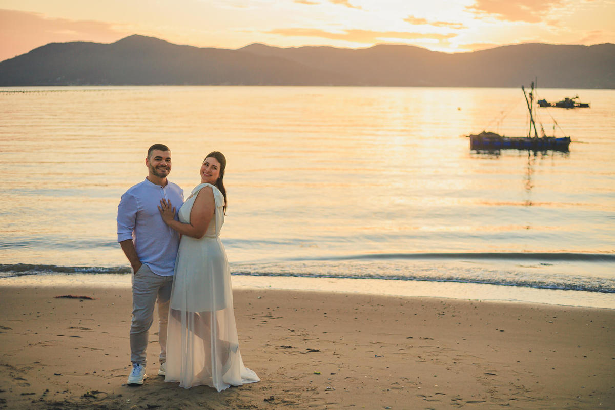 Casal de costas ao pôr do sol com vista para o mar
