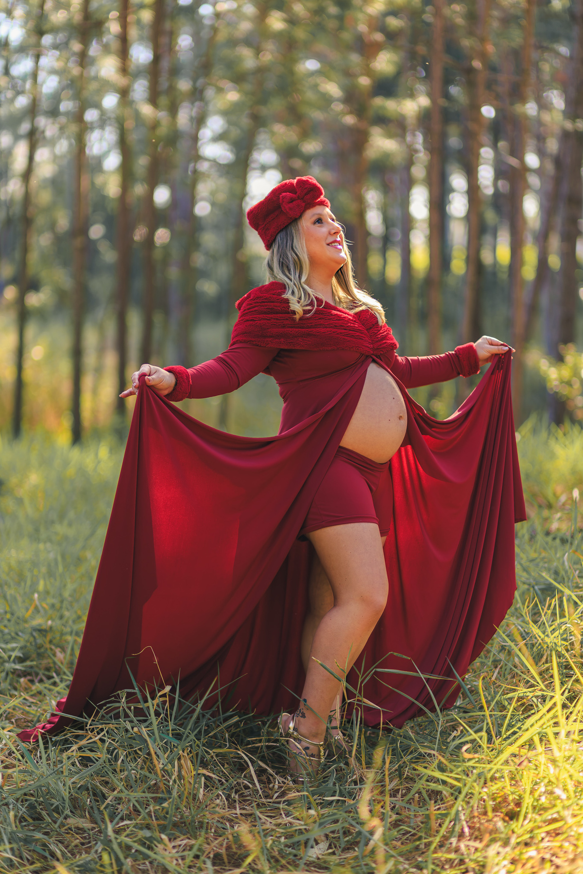Gestante com vestido vermelho esvoaçante posa entre árvores no Sul
da Ilha.