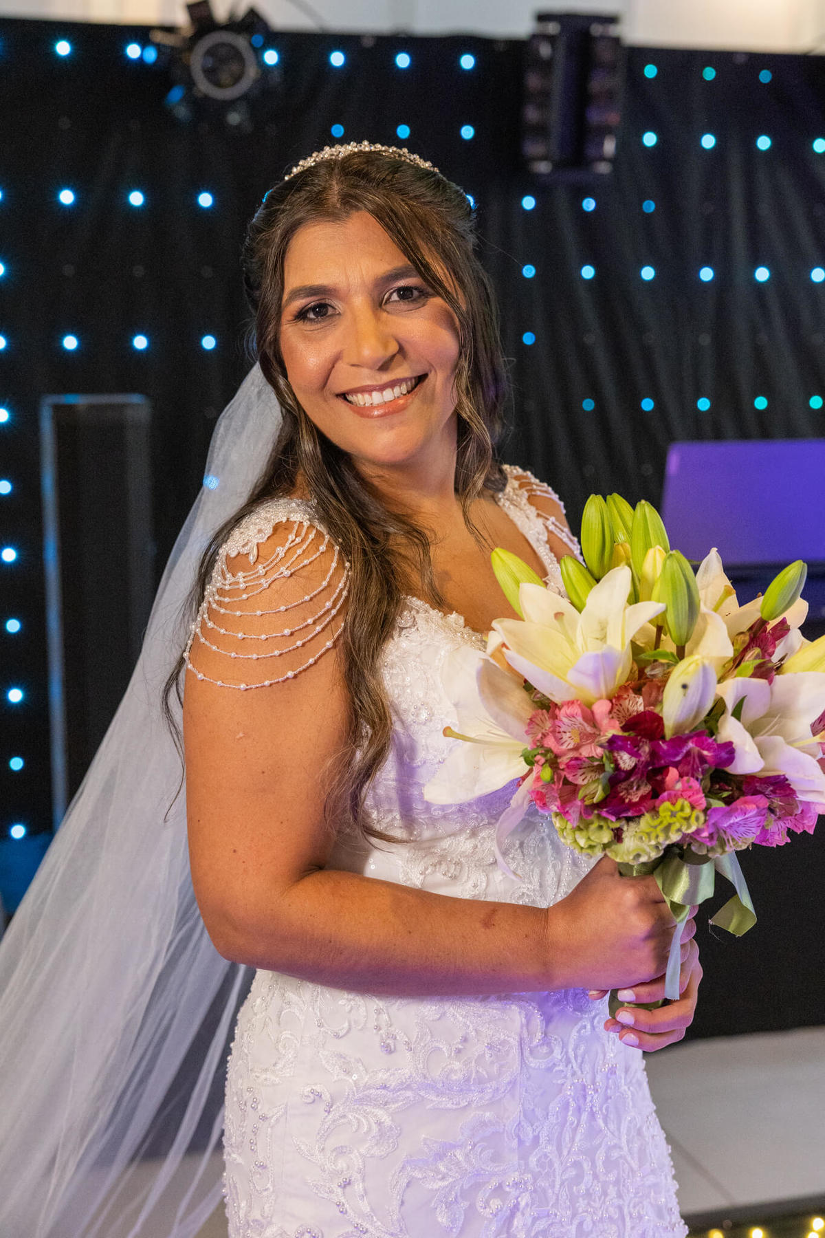 Retrato de Daiane com o vestido de noiva e o buquê antes da cerimônia.