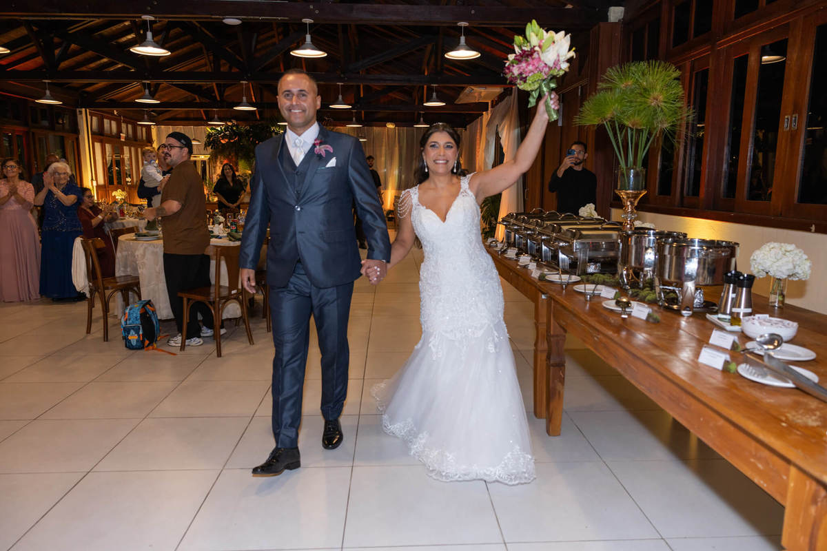 Entrada animada dos recém-casados na recepção do casamento.