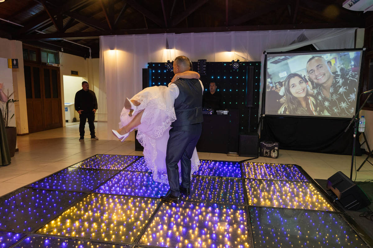 Casal celebra na pista iluminada durante a primeira dança