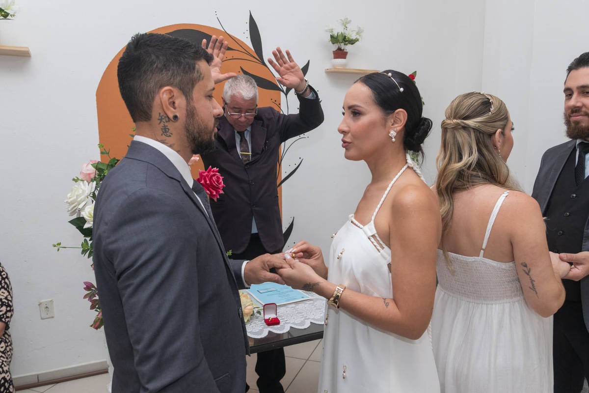 Troca de alianças do segundo casal durante o casamento civil das duas irmãs.