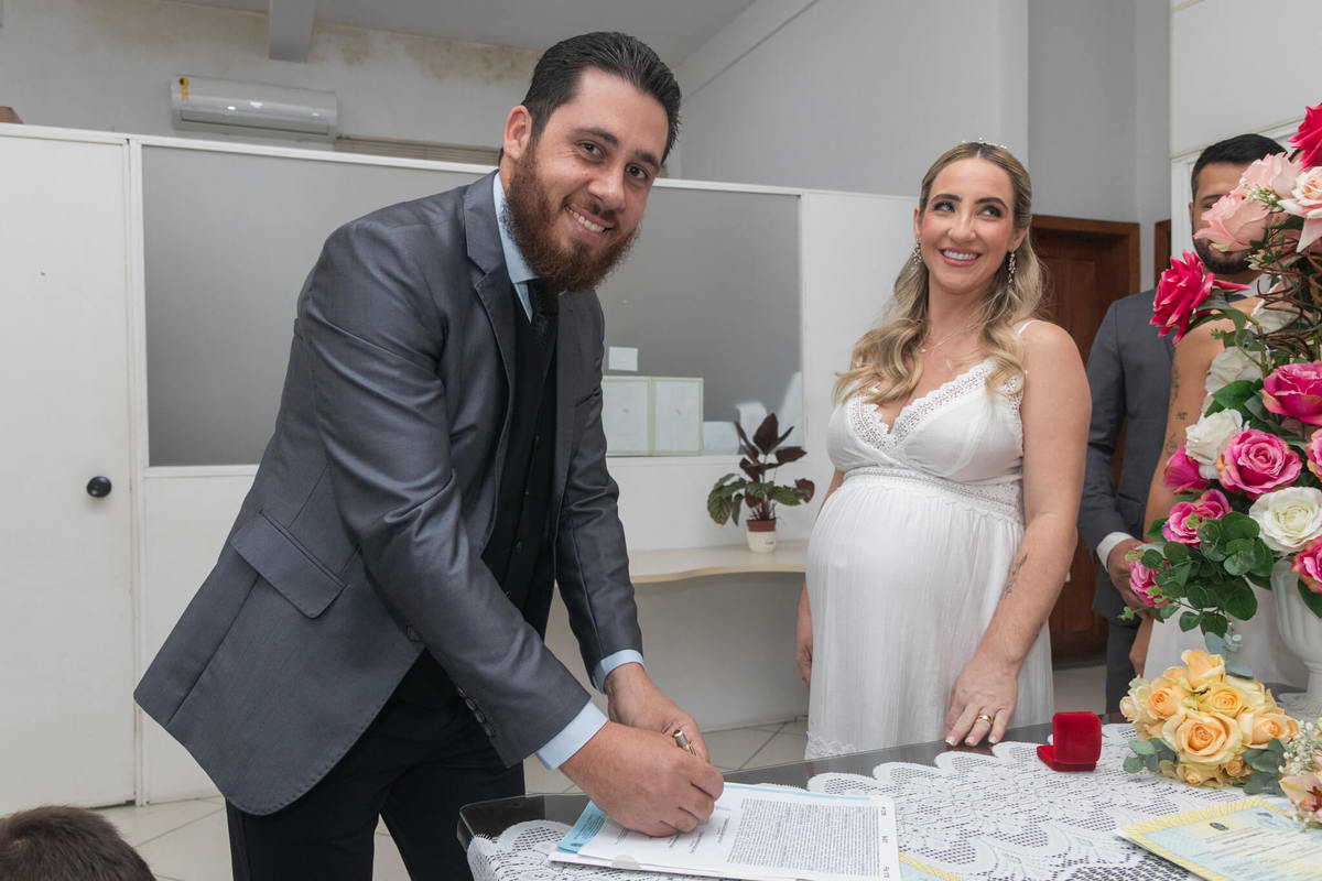 Assinatura dos documentos do casamento civil diante da família.