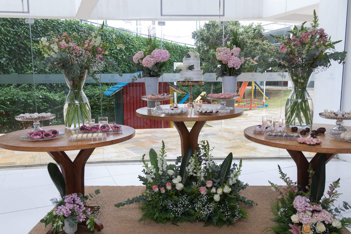 Decoração da festa conjunta com flores, doces e elementos naturais.