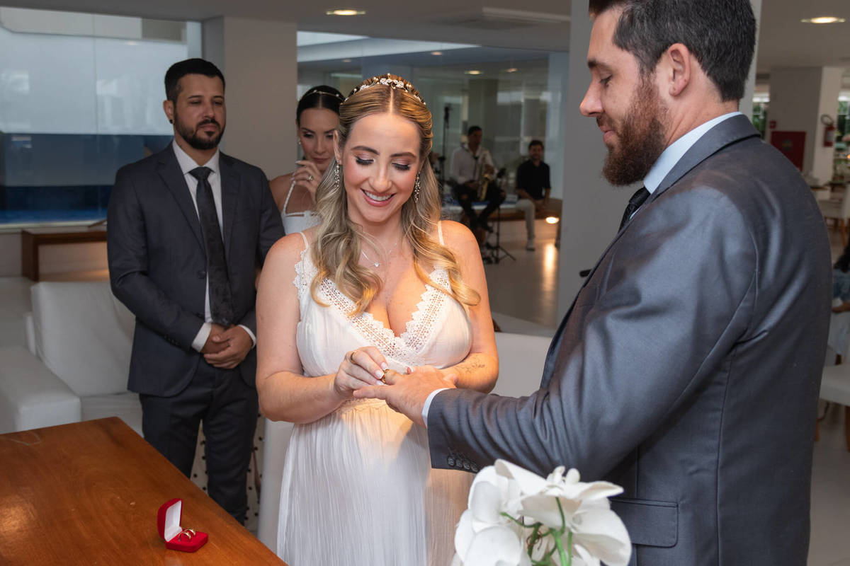 Troca de aliança de um dos casais durante a celebração em família.