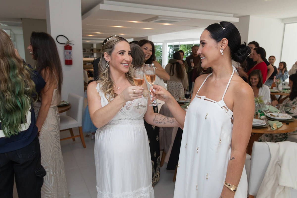 As irmãs brindam juntas durante a festa dos dois casamentos.