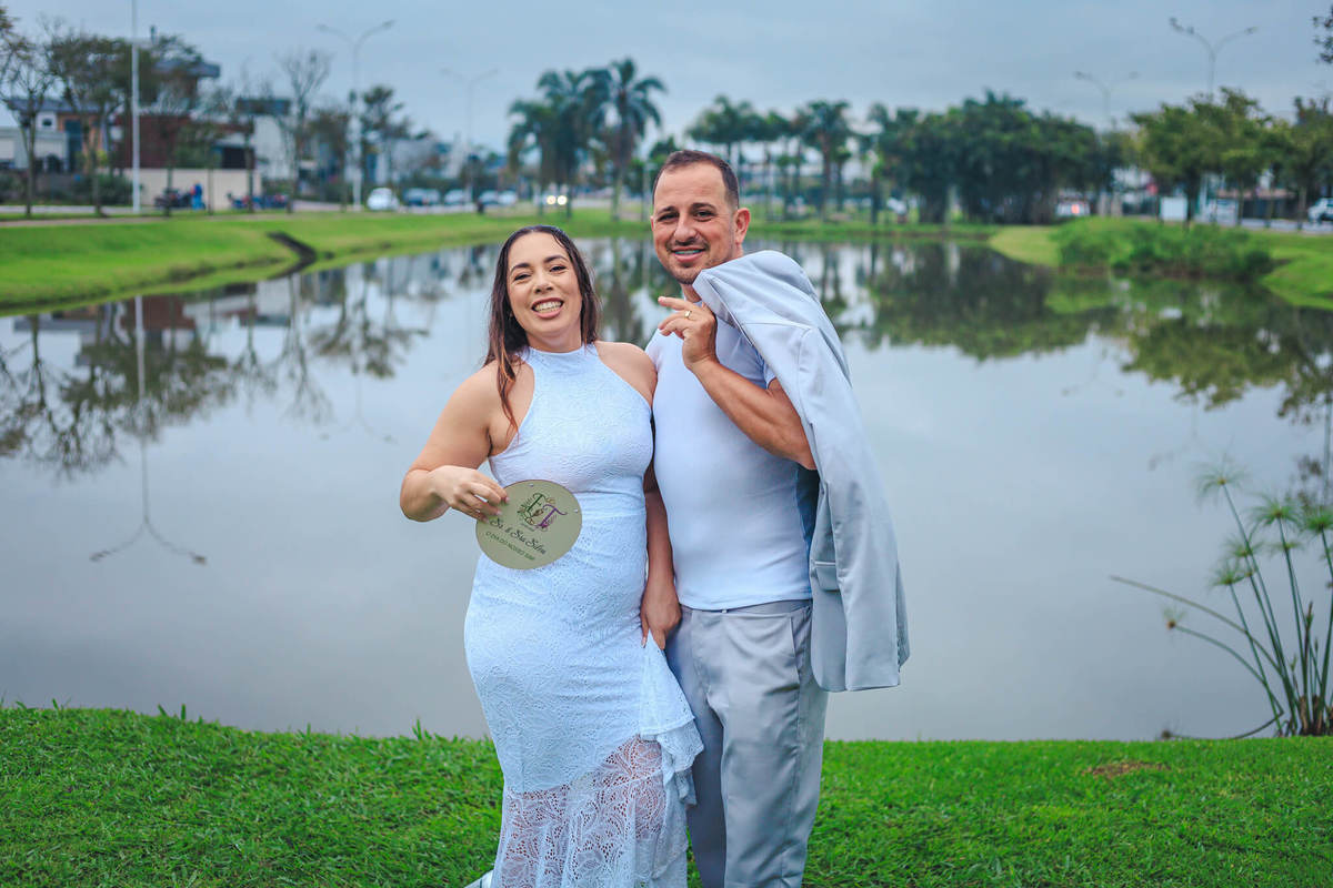Taise Silva e seu esposo posam diante do
lago no Delta Ville