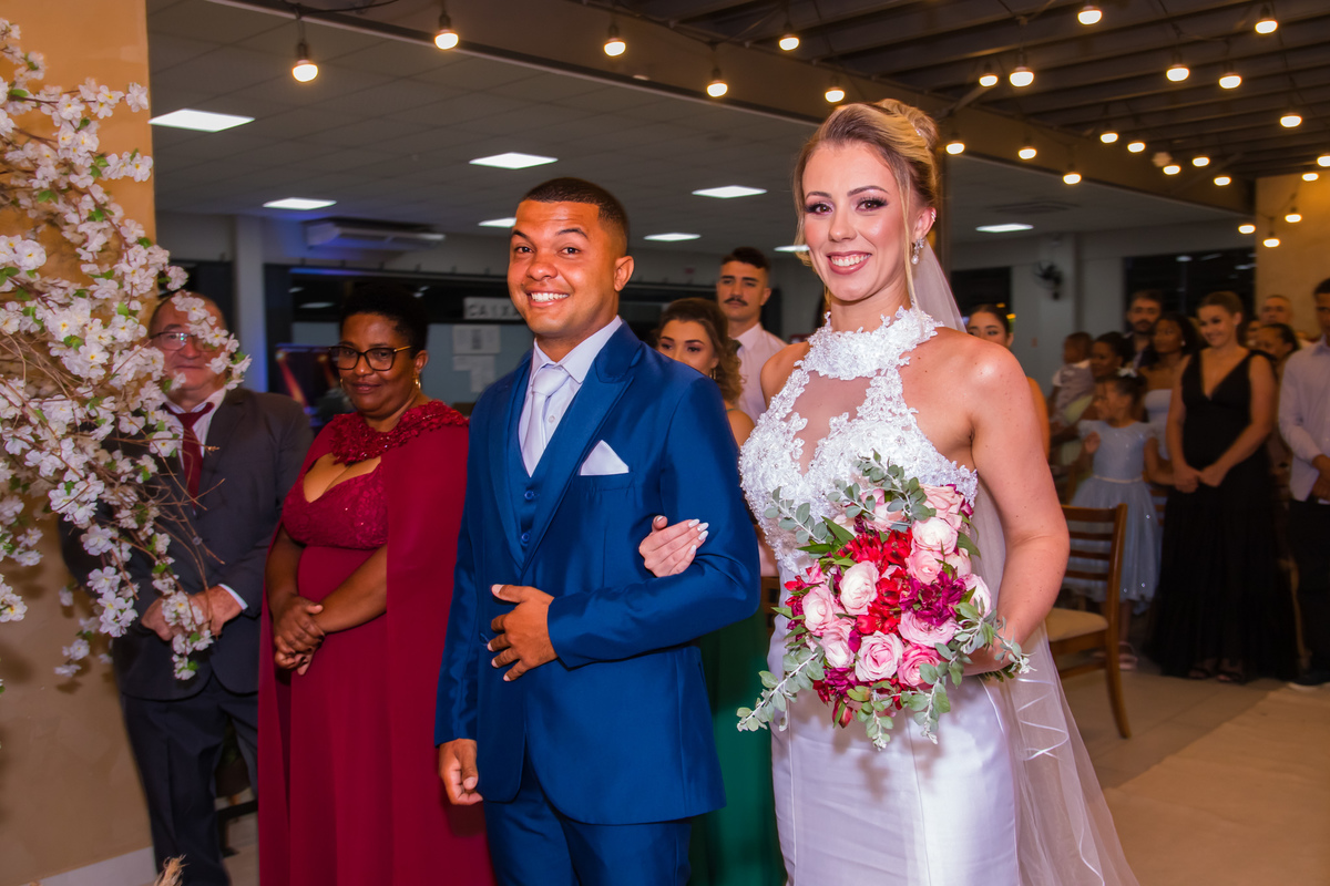 Ana e Vitor entrando juntos na cerimônia de casamento diante dos familiares e convidados.