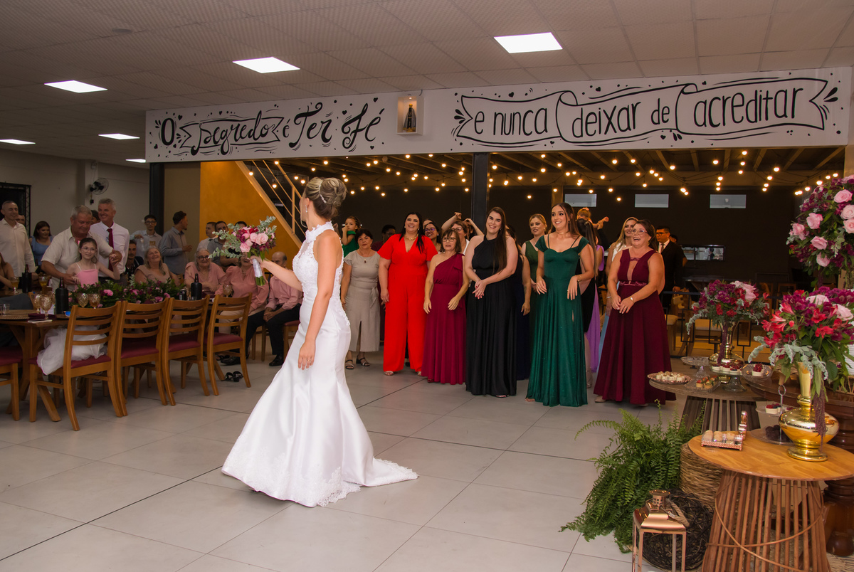 Noiva se preparando para jogar o buquê durante a festa de casamento.