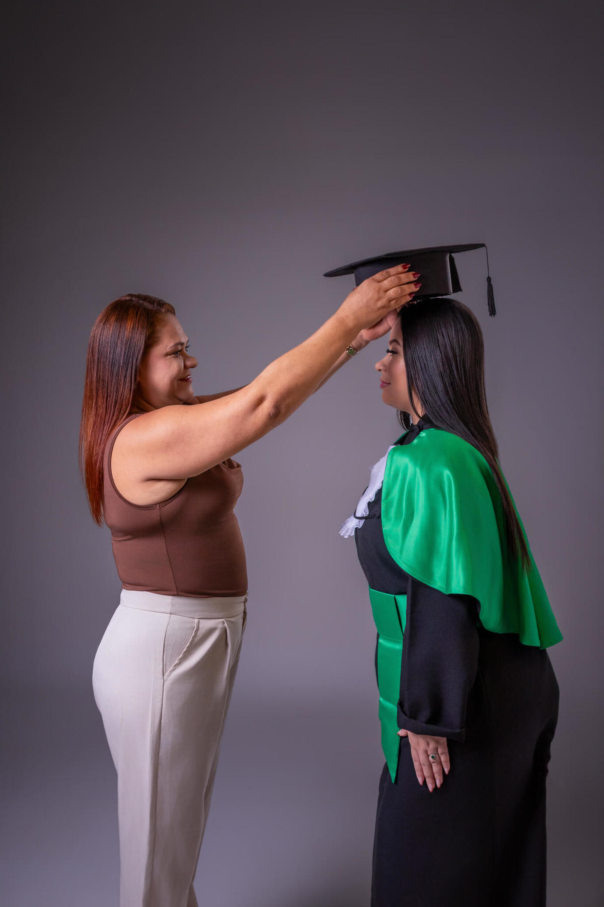 Mãe colocando o capelo na filha durante ensaio de formatura de Enfermagem em Florianópolis