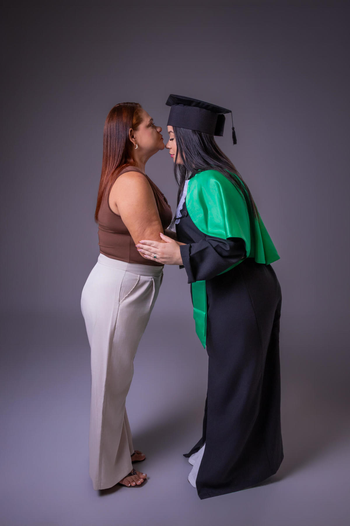 Momento de emoção entre mãe e filha no ensaio de formatura com beca em Florianópolis