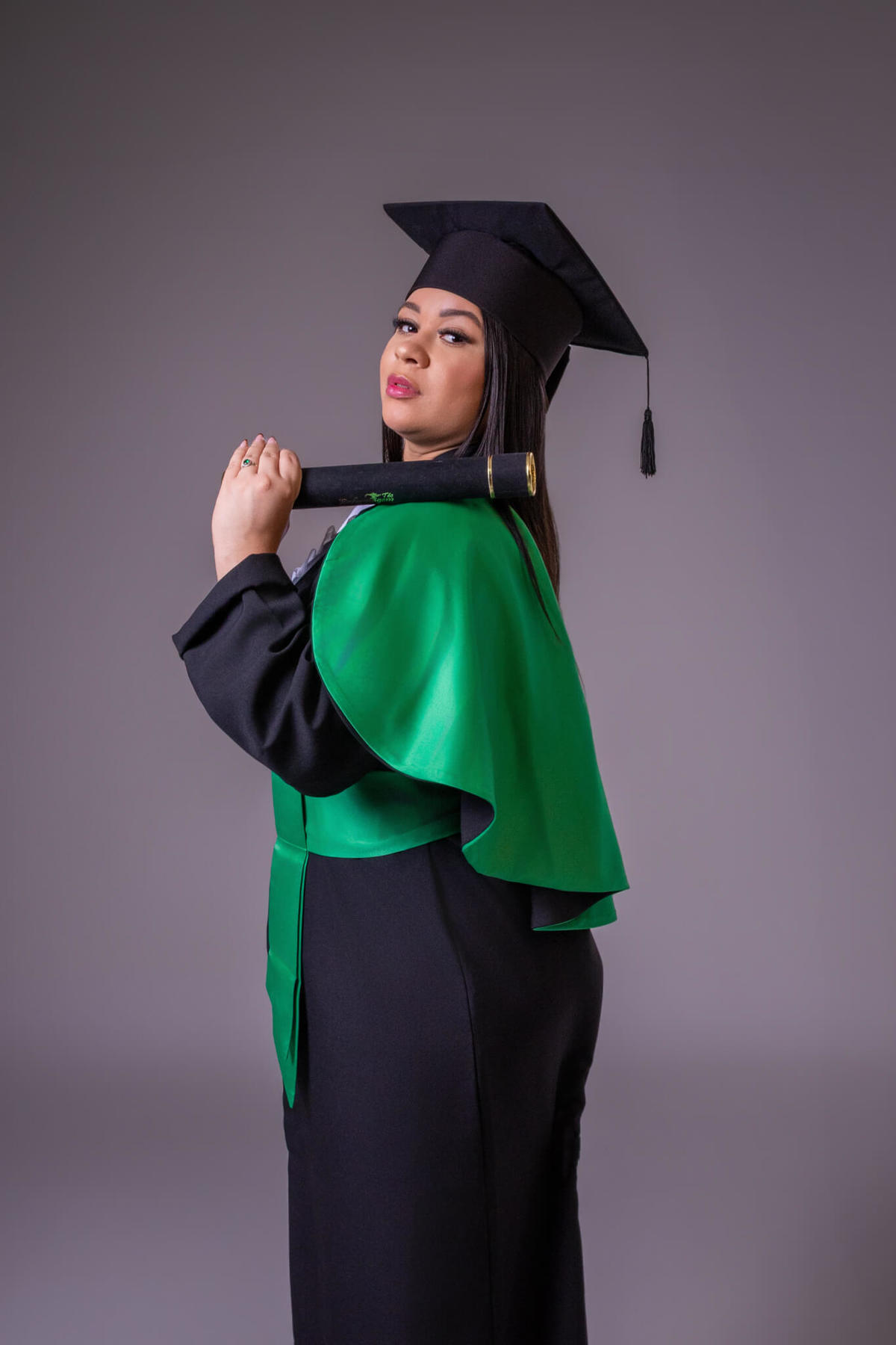 Retrato clássico de formatura com beca e faixa verde da Enfermagem em estúdio em Florianópolis