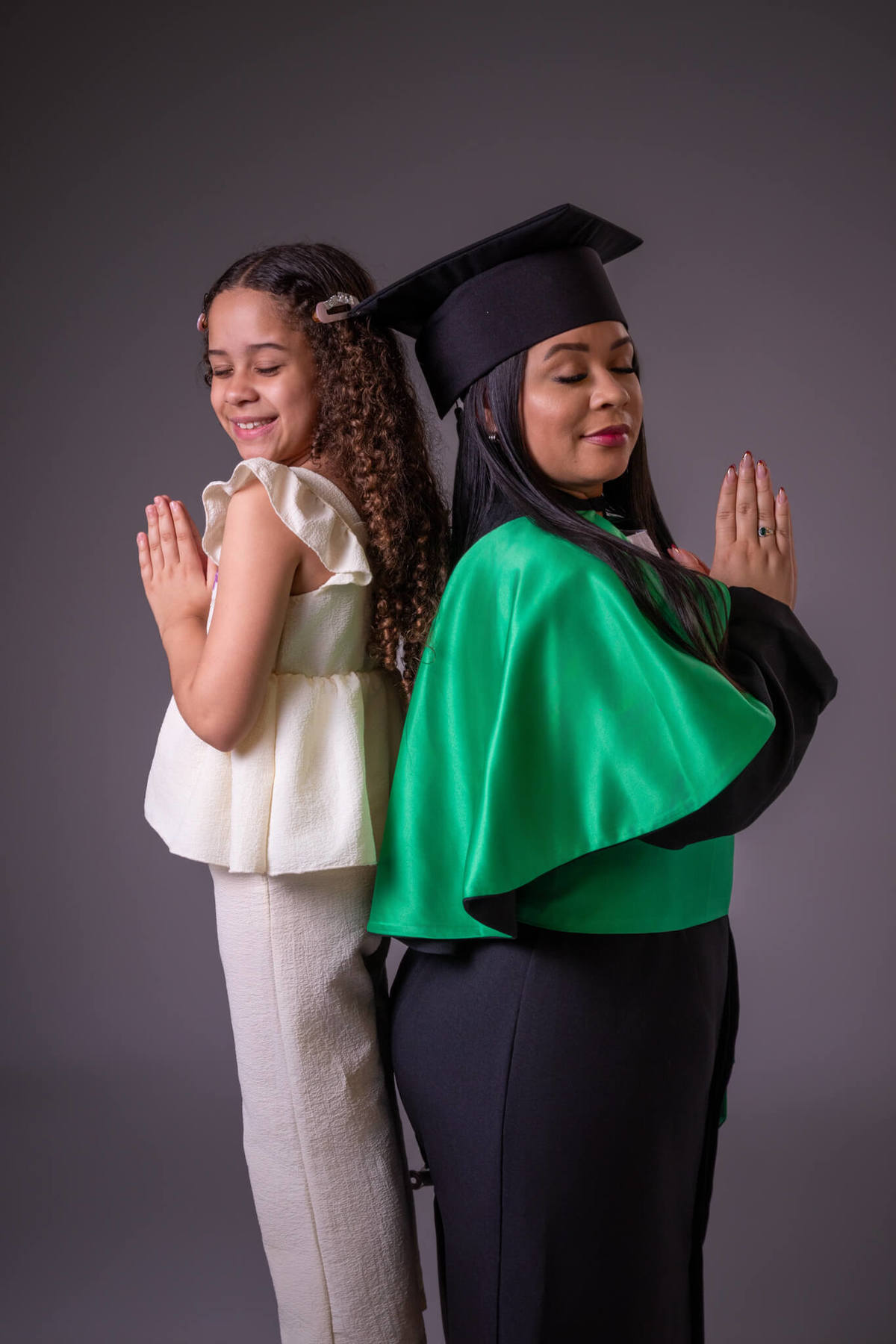 Foto criativa de mãe formanda de beca e filha agradecendo pela formatura em Enfermagem