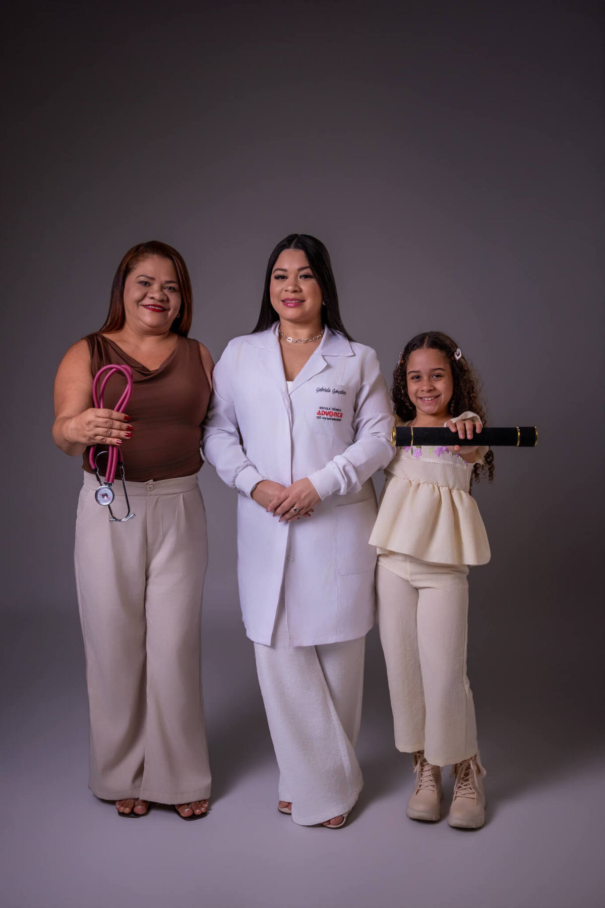 Ensaio de formatura de Enfermagem com jaleco e família em Florianópolis - Mãe, formanda e filha