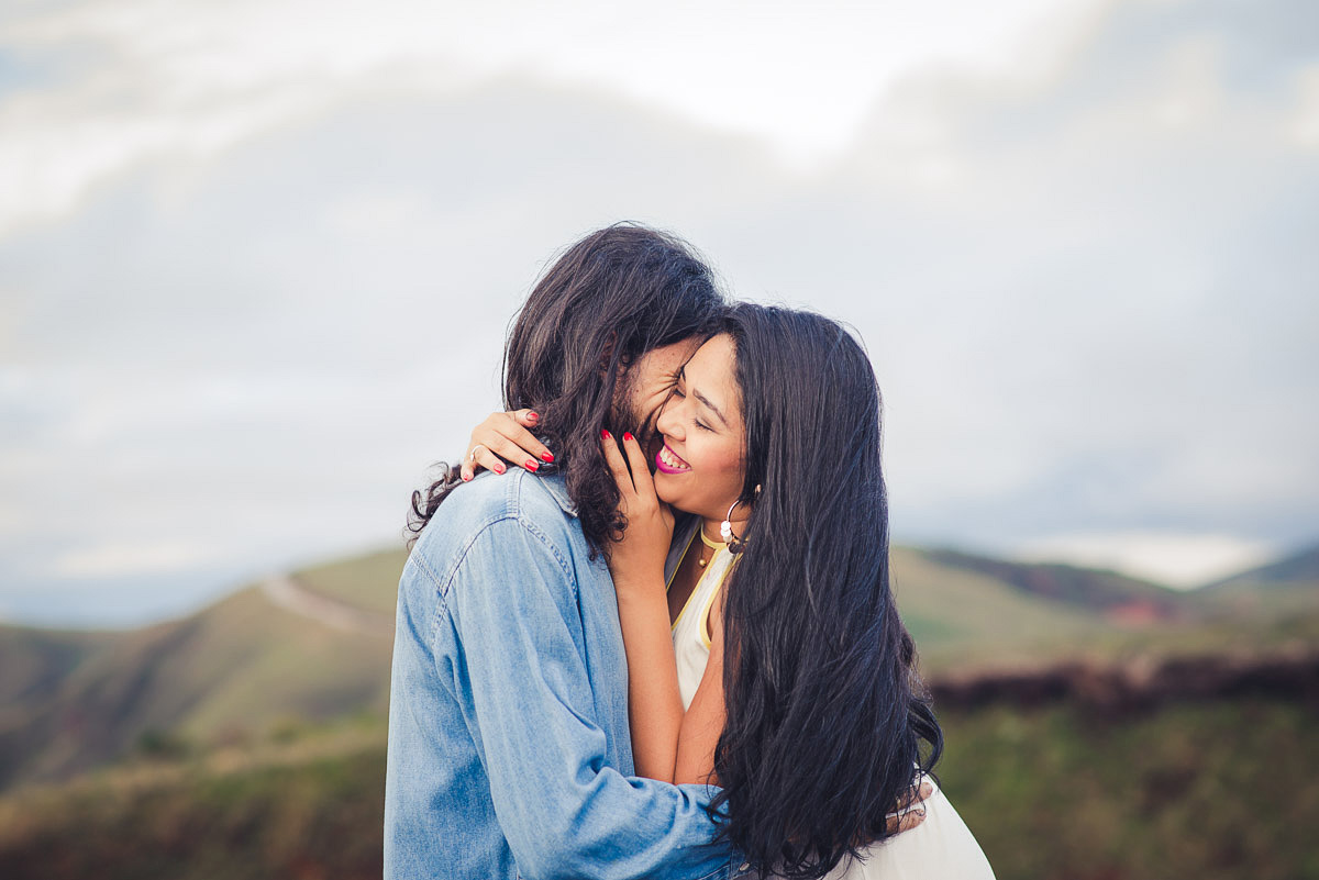 noiva sorrindo ao abraçar o noivo no ensaio de pre casamento na serra do rola moça no click do fotografo de casamentos em belo horizonte João Paulo