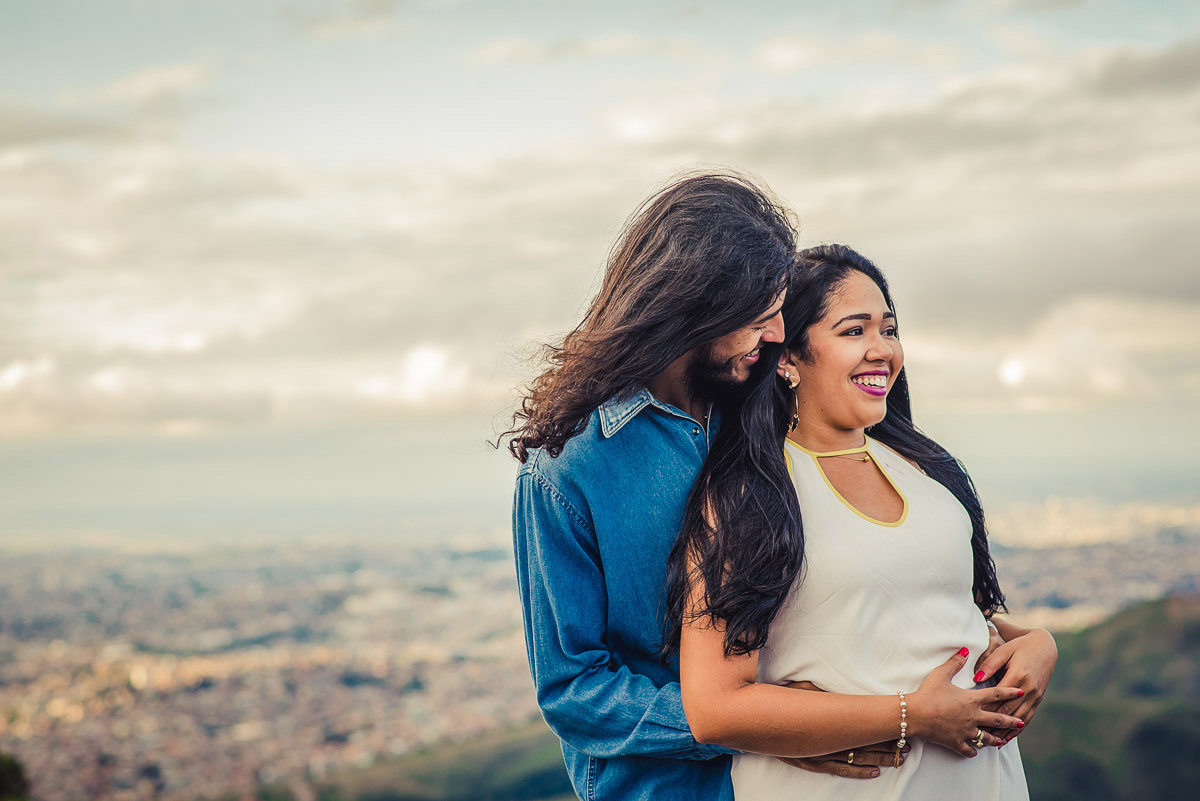 Noivo abraçando a noiva com a bela vista da serra do rola moça no ensaio pre wedding feito pelo fotografo de casamentos em belo horizonte João Paulo