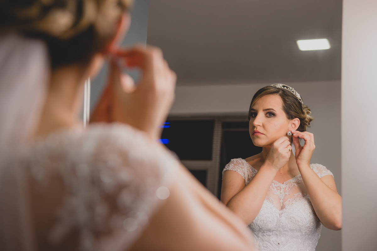 noiva colocando o brinco para o casamento no making off em belo horizonte