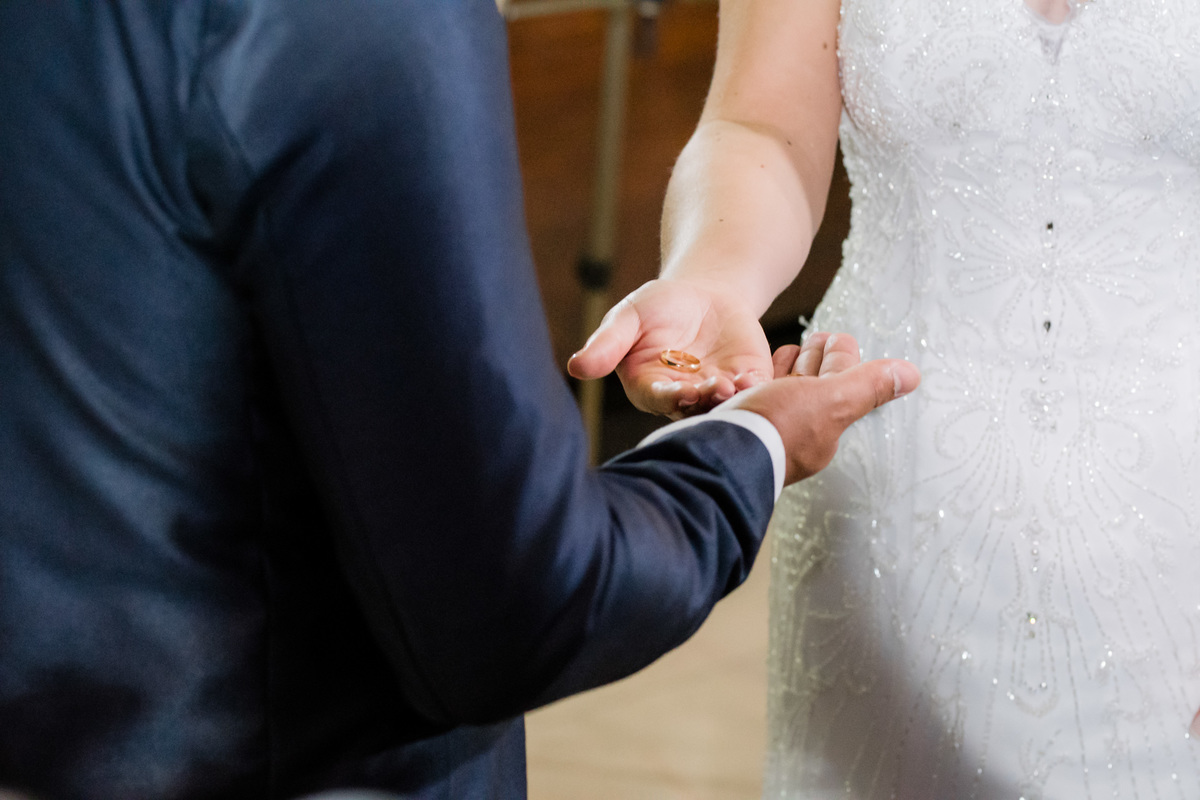 noivos segurando as alianças de casamento no altar  registrado pelo fotógrafo de casamentos em belo horizonte joão paulo