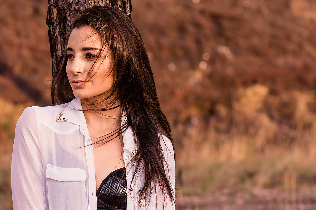 modelo com cabelos ao vendo no ensaio externo feminino feito na linha de trem no Belvedere em belo horizonte