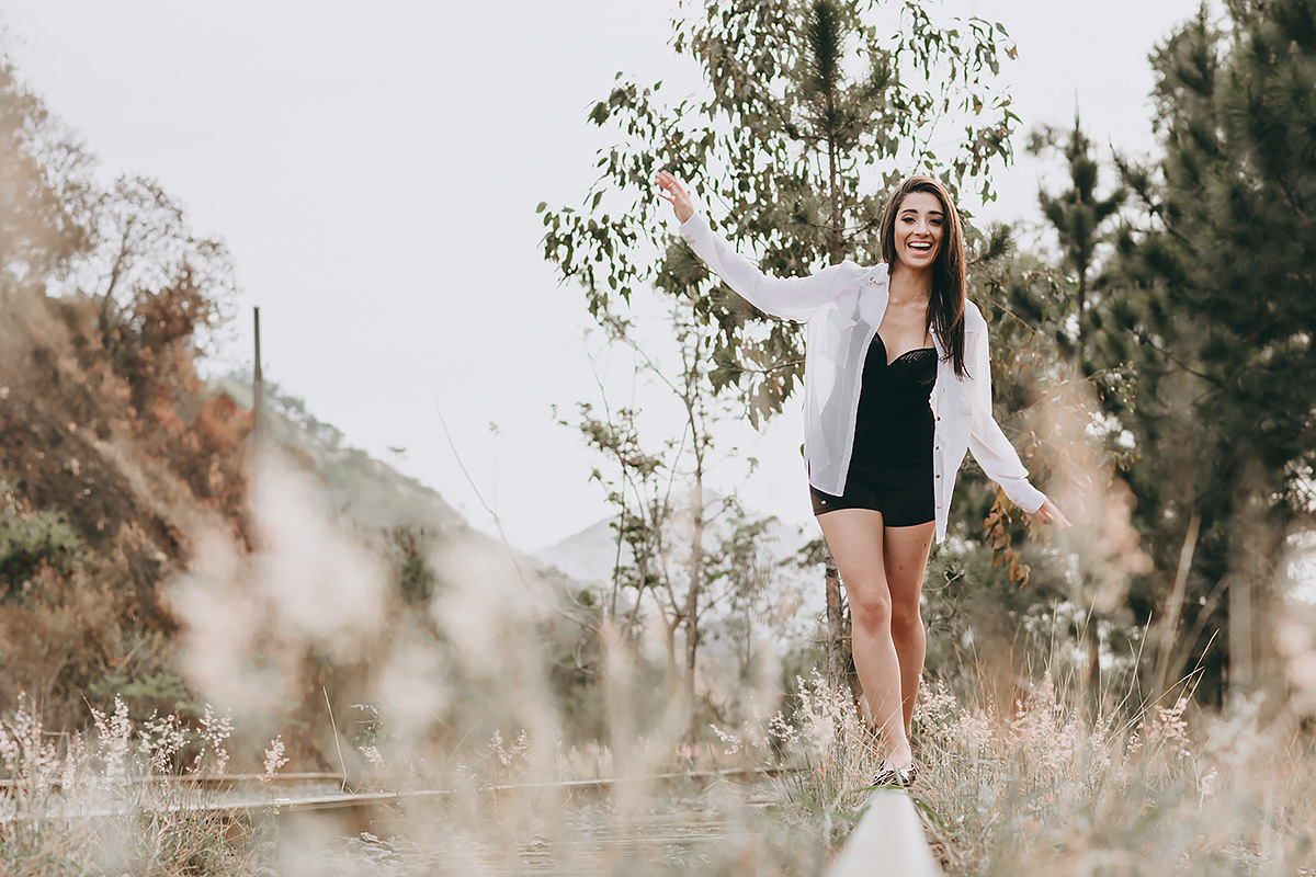 mulher andando na linha de trem no ensaio feminino feito na linha de trem do Belvedere em Belo Horizonte