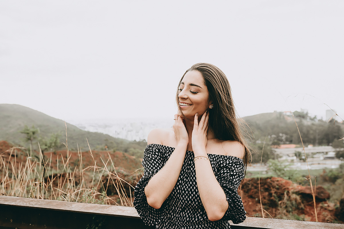 Modelo sorrindo no ensaio feminino com a imagem de belo horizonte ao fundo
