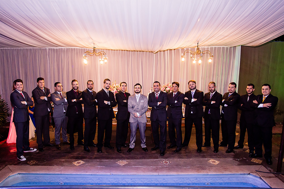 padrinhos reunidos com  o noivo em frente a mesa do bolo de casamento