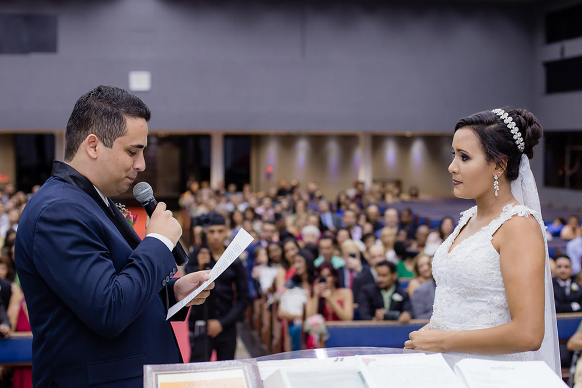 noivo lendo os votos para a noiva no altar do dia do casamento em belo horizonte