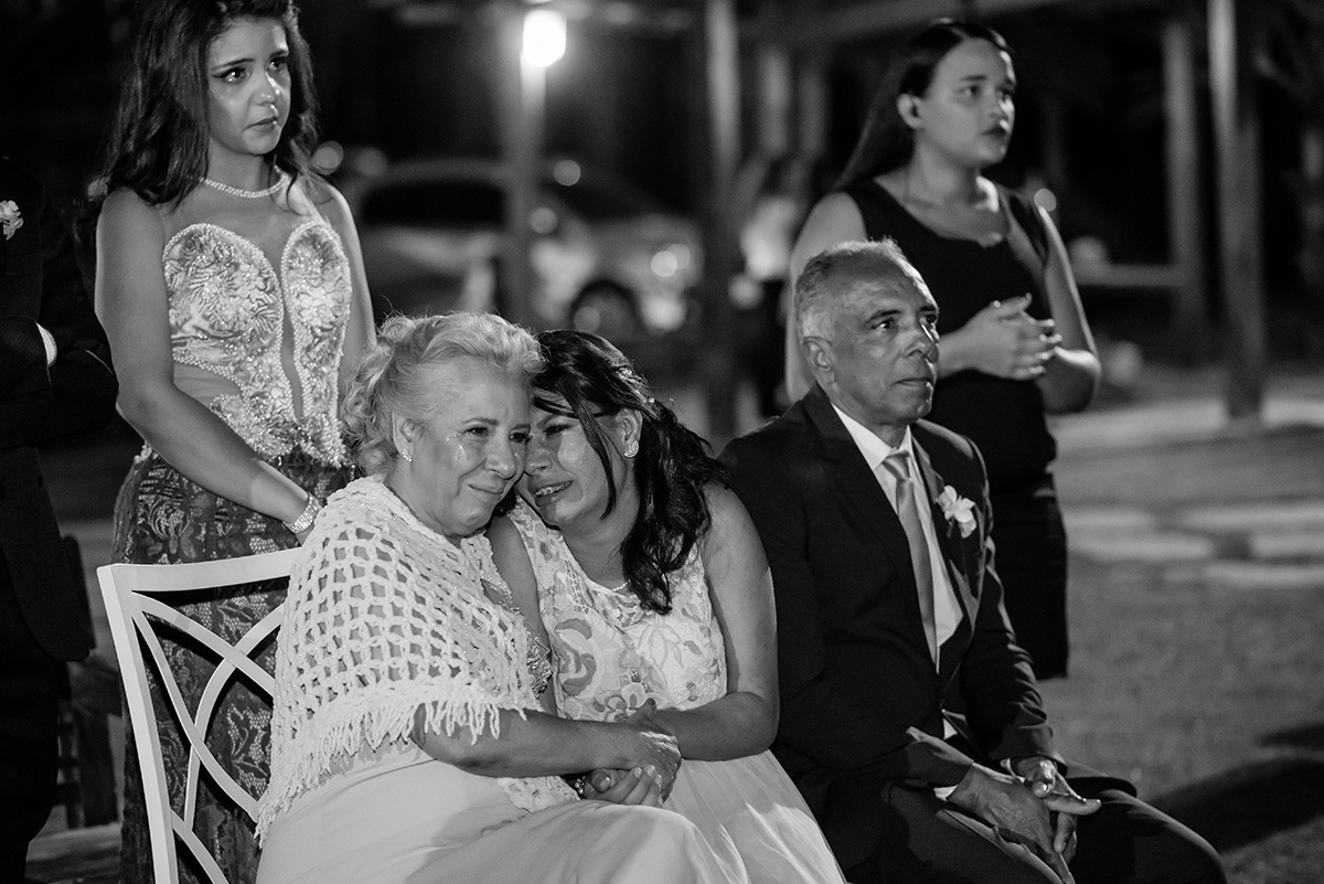 mãe  da noiva e imrã da noiva emocionadas chorando no casamento ao ar livre em contagem