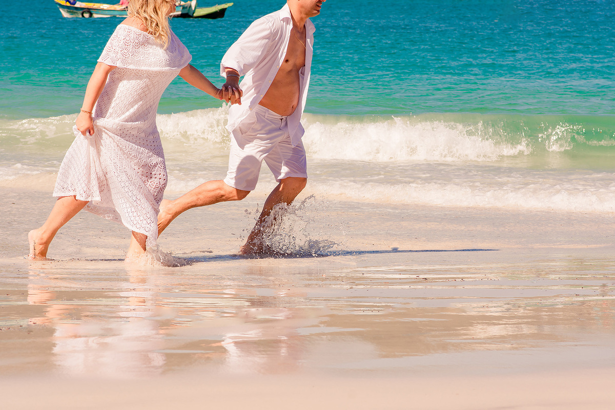 noivos correndo de mãos dadas nas praias do pontal do atalaia no pre wedding em arraial do cabo