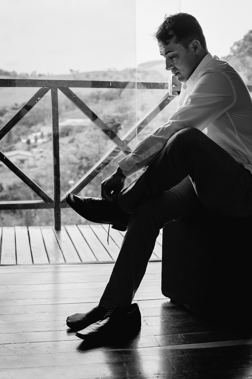 detalhe do noivo colocando o sapato no making off do noivo