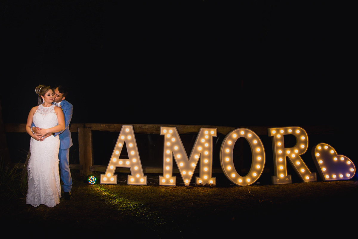 noivos abraçados próximo ao letreiro luminoso amor em belo horizonte