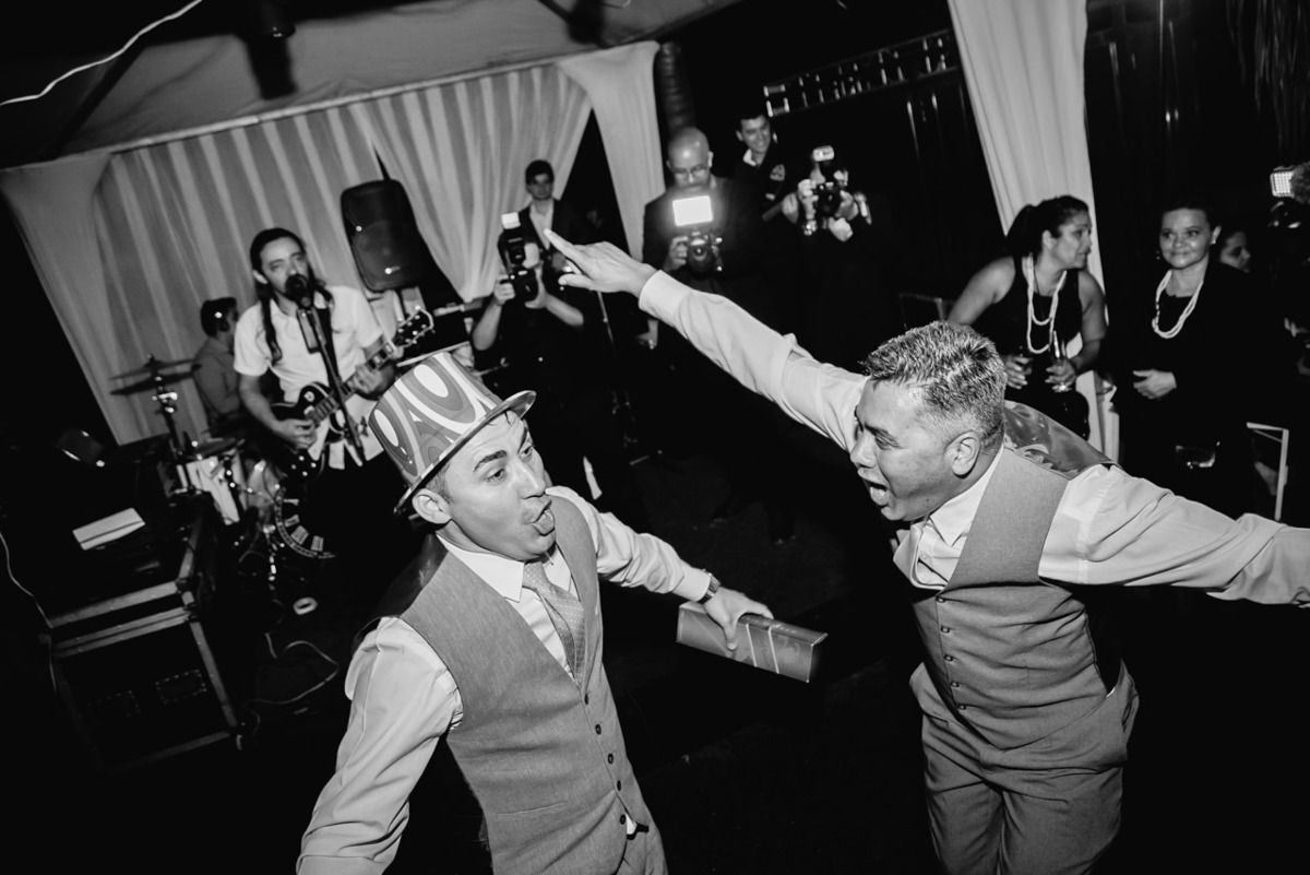noivo dançando feliz na festa de casamento com os padrinhos