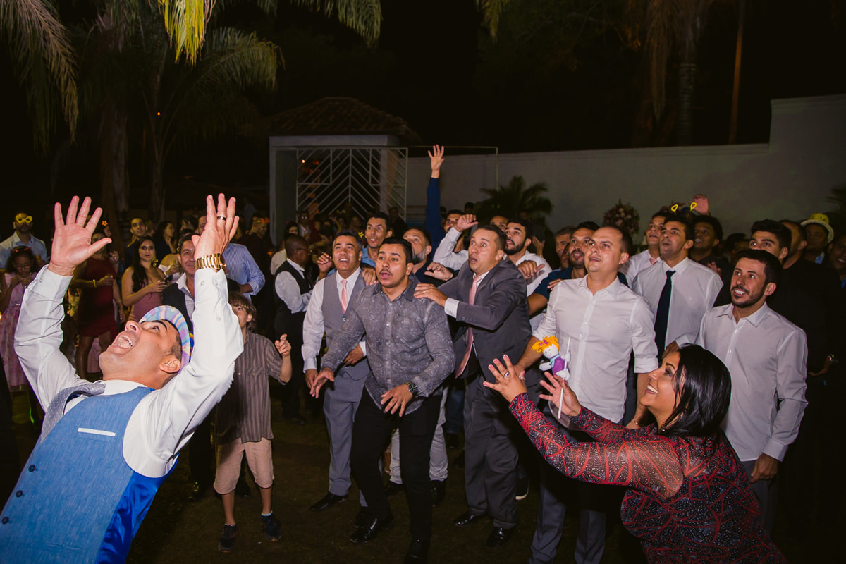 noivo jogando caixa de Whisky na festa de casamento com os padrinhos ao fundo