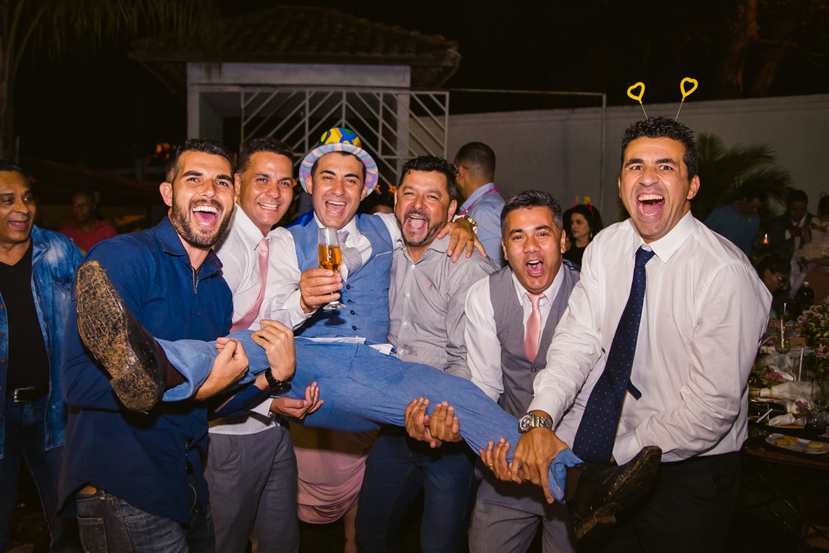 padrinhos carregando noivo no colo na festa de casamento ao ar livre em Belo horizonte