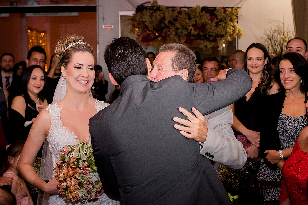 pai da noiva abraçando o noivo na foto do fotografo de casamentos em belo horizonte joão paulo