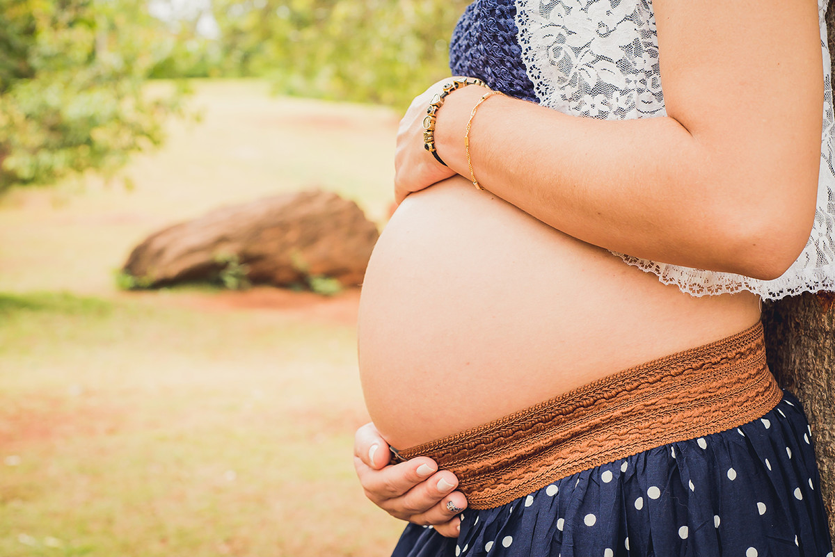Gestante acariciando a barriga de grávida no parque das águas em belo horizonte