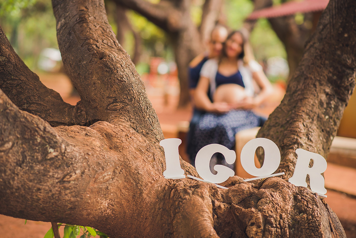 Letras em mdf forma o nome do Bebê Igor em uma arvore com os pais ao fundo no parque das águas no barreiro em belo horizonte BH