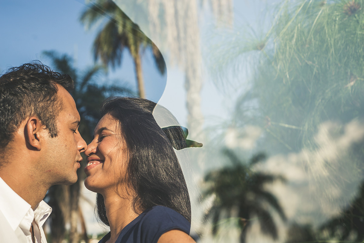 Casal sorrindo encostando nariz com nariz com uma bela paisagem do museu de arte da Pampulha em Belo horizonte BH MG