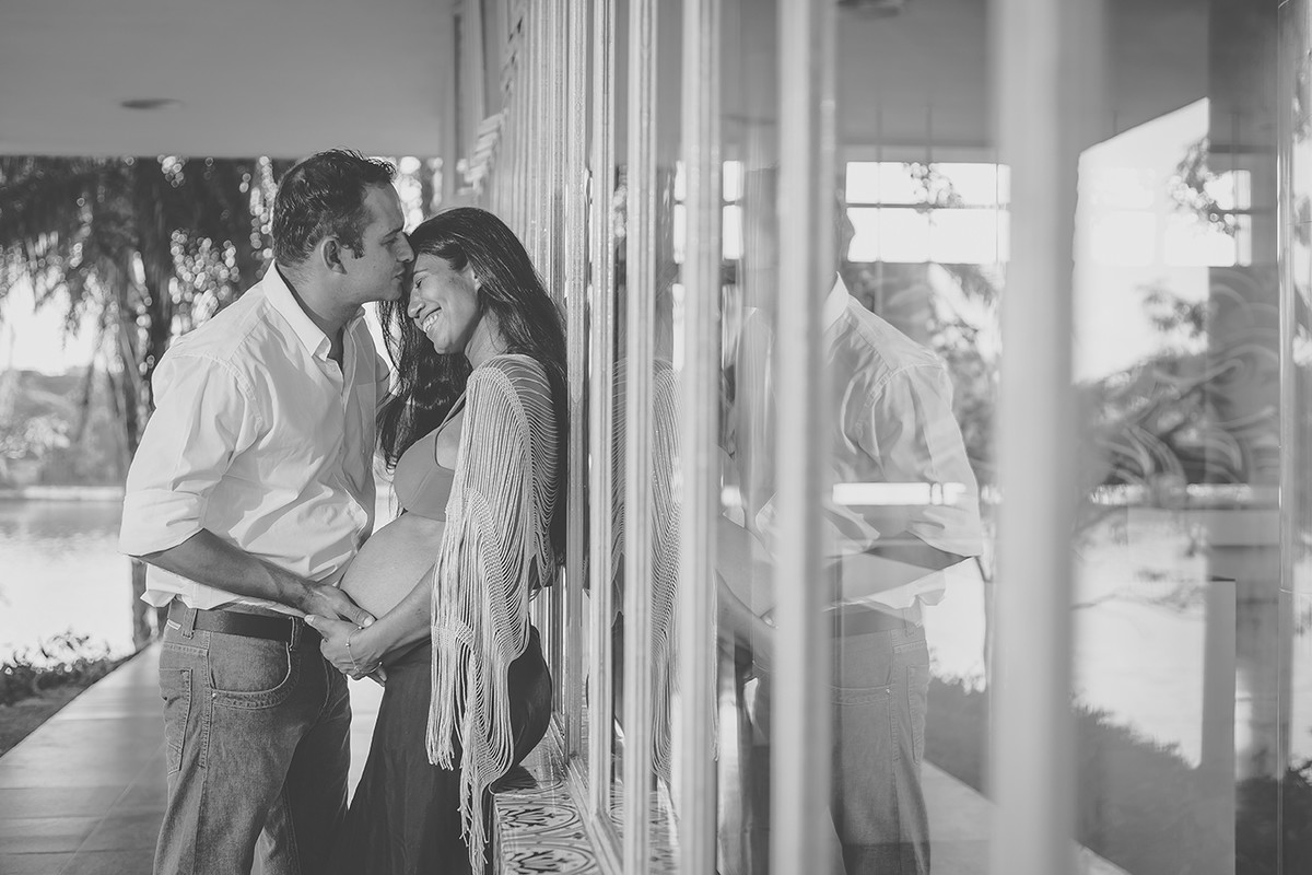 Casal sorrindo no ensaio de gestante no museu da Pampulha em Belo Horizonte MG