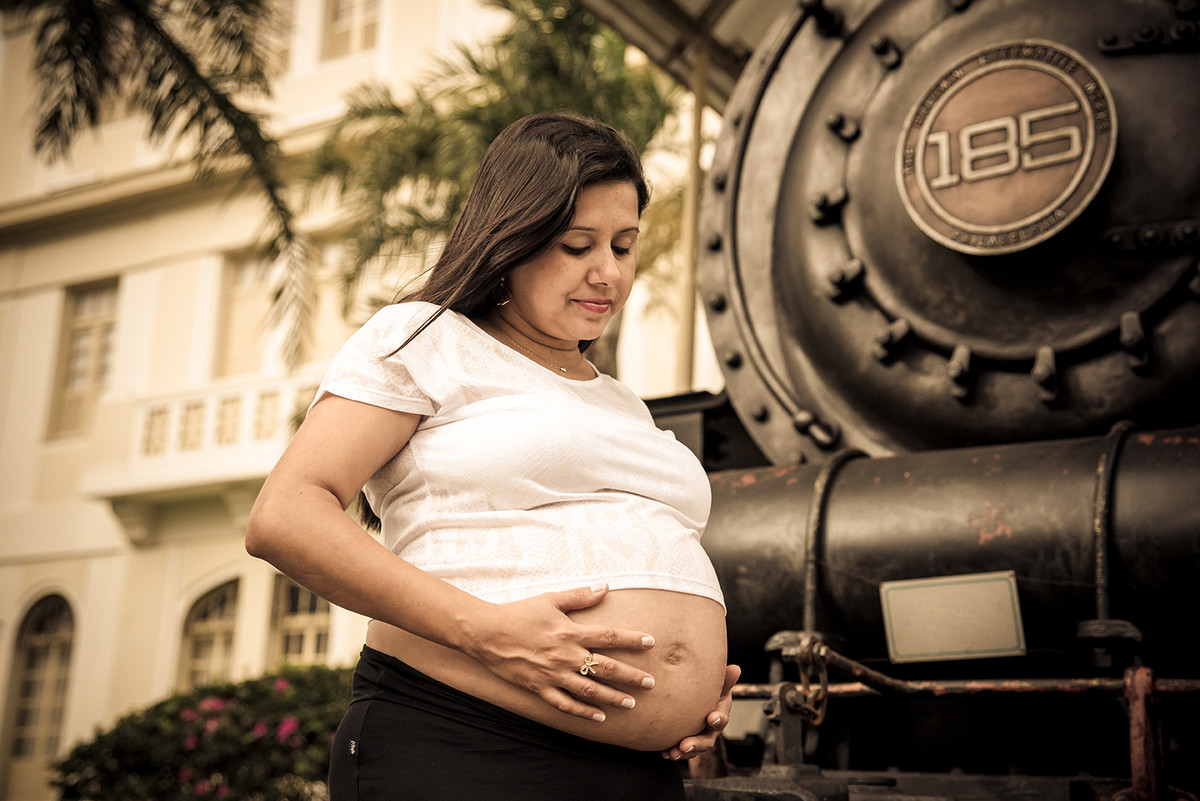 Gestante na frente da locomotiva no museu da vale ES