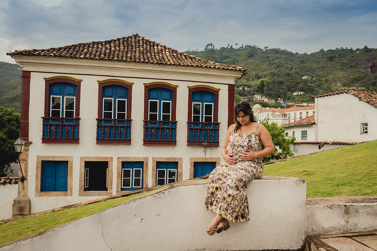 Gestante sentada em uma escada em frente a uma igreja em ouro preto MG